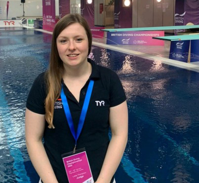 Lottie Thompson sitting with a swimming pool behind her.